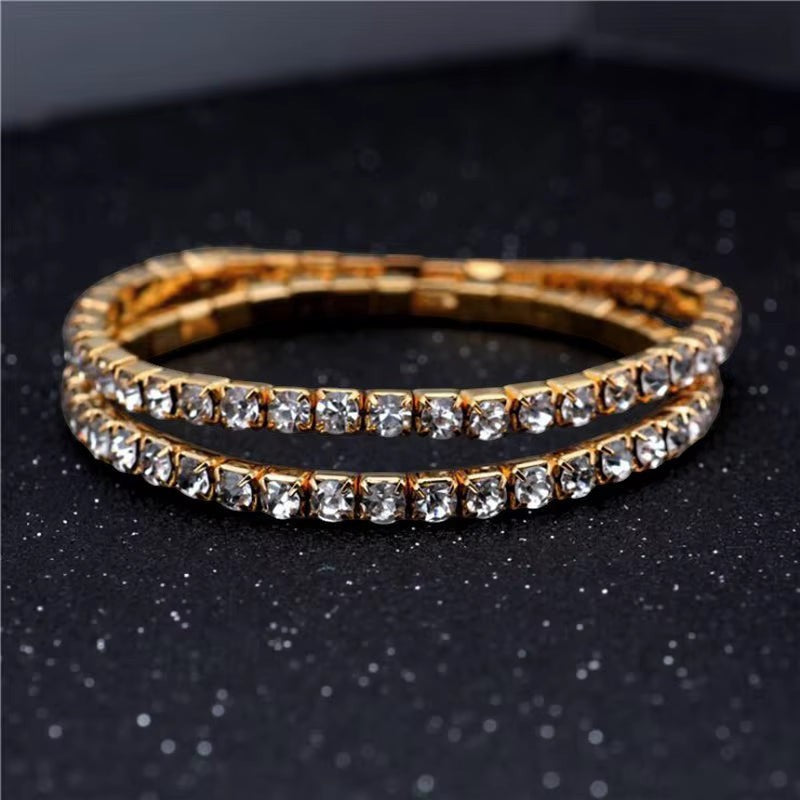 My Store elegant gold-tone tennis bracelet featuring a continuous row of sparkling clear crystals on a dark background