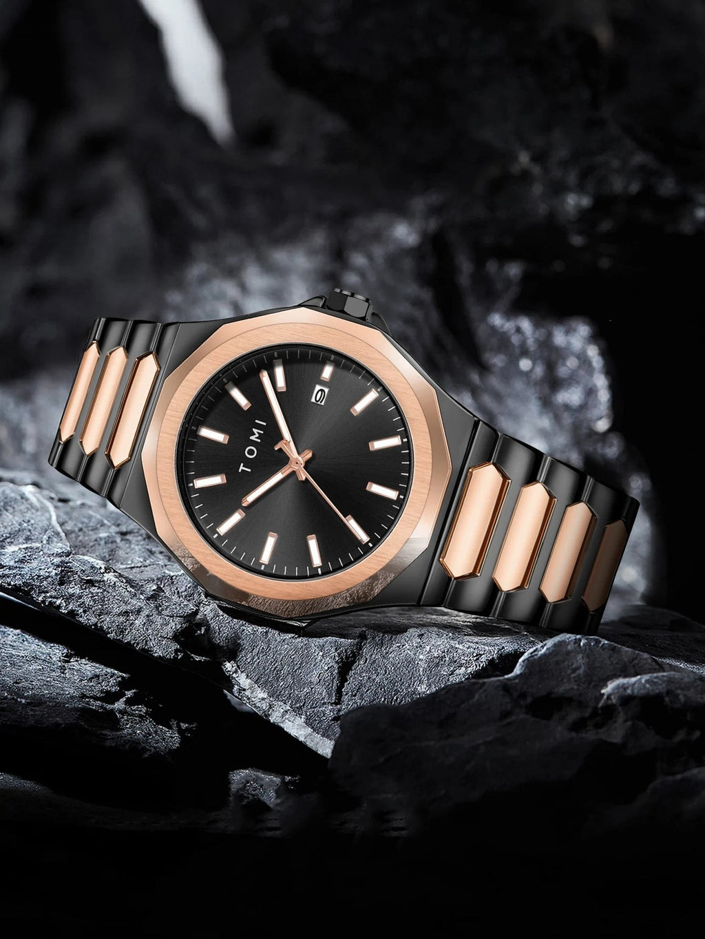 My Store TOMI luxury stainless steel wristwatch in black and rose gold resting on a dark textured stone surface.